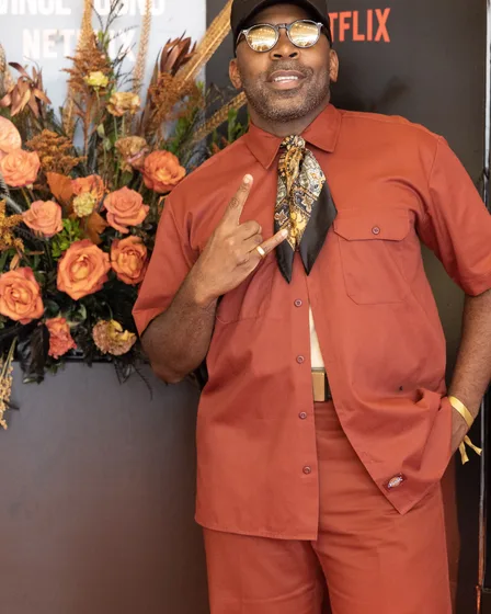 Guest in a rust suit beside the floral arrangement